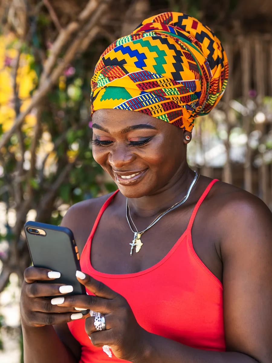 A Lagos market trader receiving payment on her phone